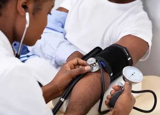 A medical student taking the blood pressure of a patient.
