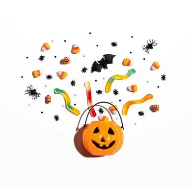 a plastic jack-o-lantern bucket with candy, bats and spiders coming out of it