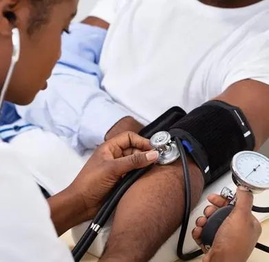 A medical student taking the blood pressure of a patient.